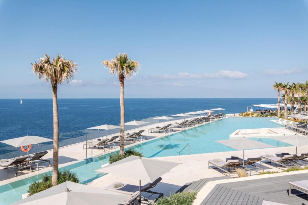 top view of an elegant outdoor pool facing the blue waters of the sea in Ibiza