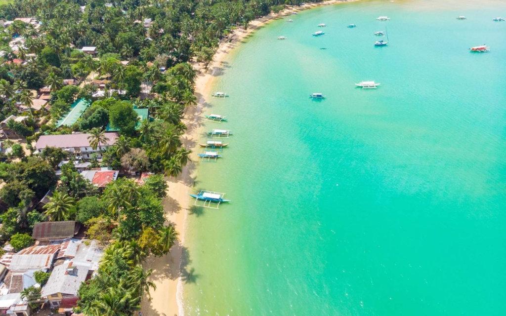 
Aerial view of Port Barton Beach with boats in turquoise water