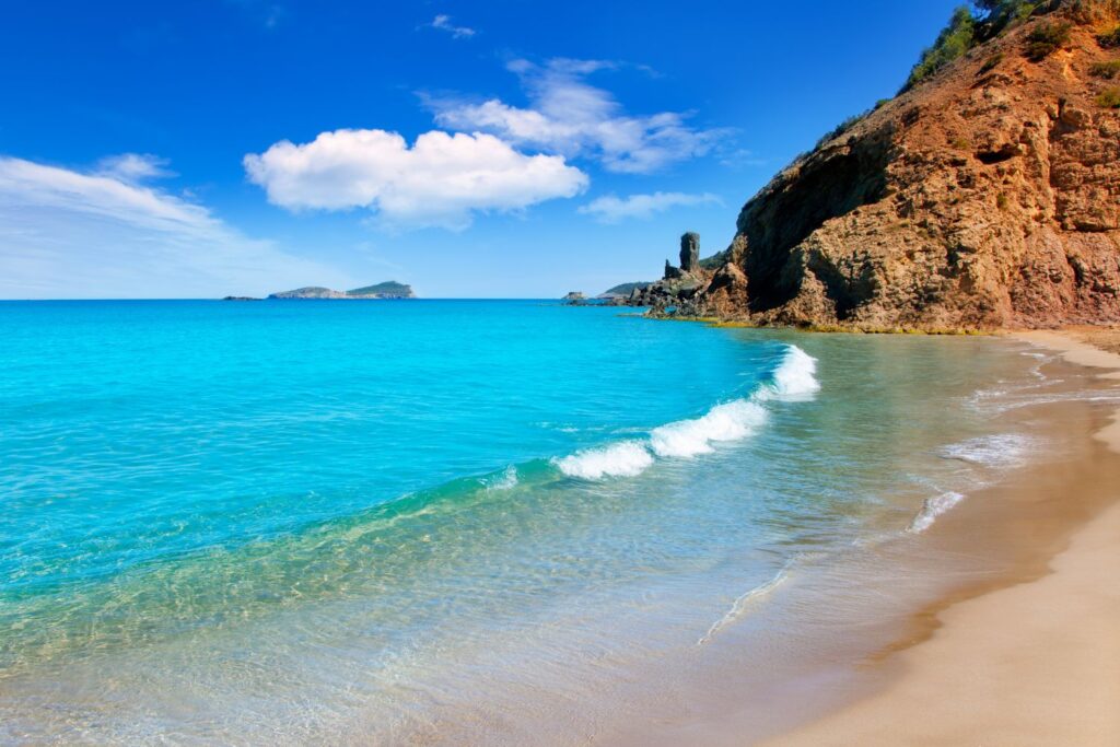 blue waters splashing at the shore of Aguas Blancas Ibiza