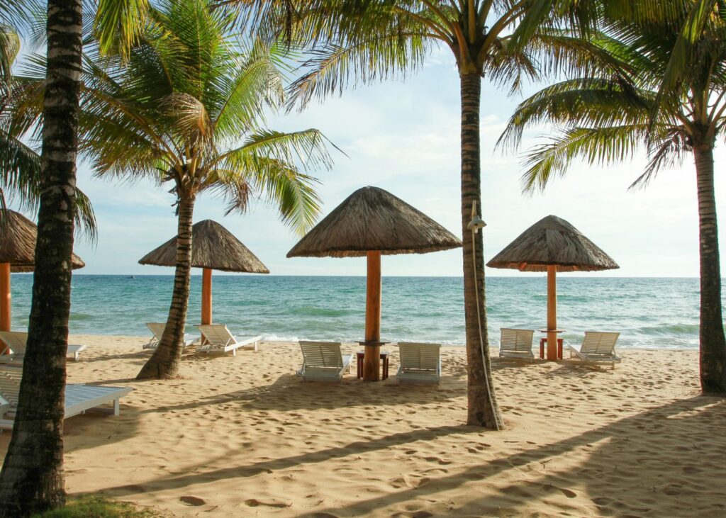 Beach with palm trees and tiki huts in Phu Quoc Vietnam