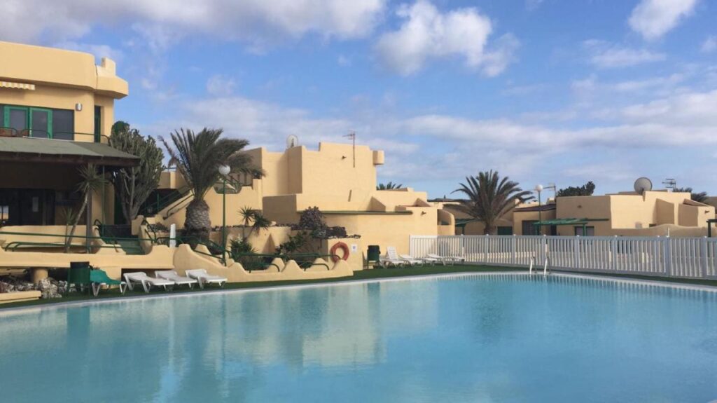 view of the apartment from outside with a pool at the front