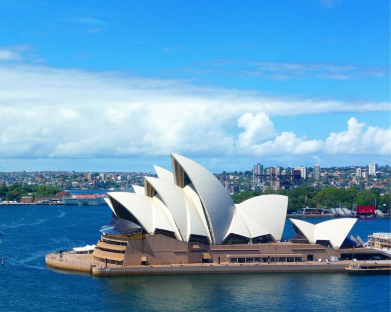 Iconic Sydney Opera House against a clear sky, showcasing its unique architectural design and stunning waterfront location in Australia.
