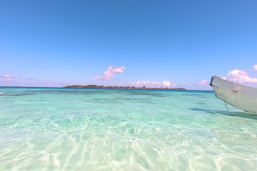 Clear water, boat, and distant island in Balabac Palawan