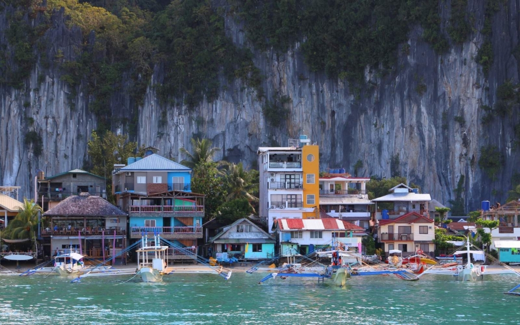 El Nido town against a limestone mountain with water in front, one of the best options of where to stay in Palawan
