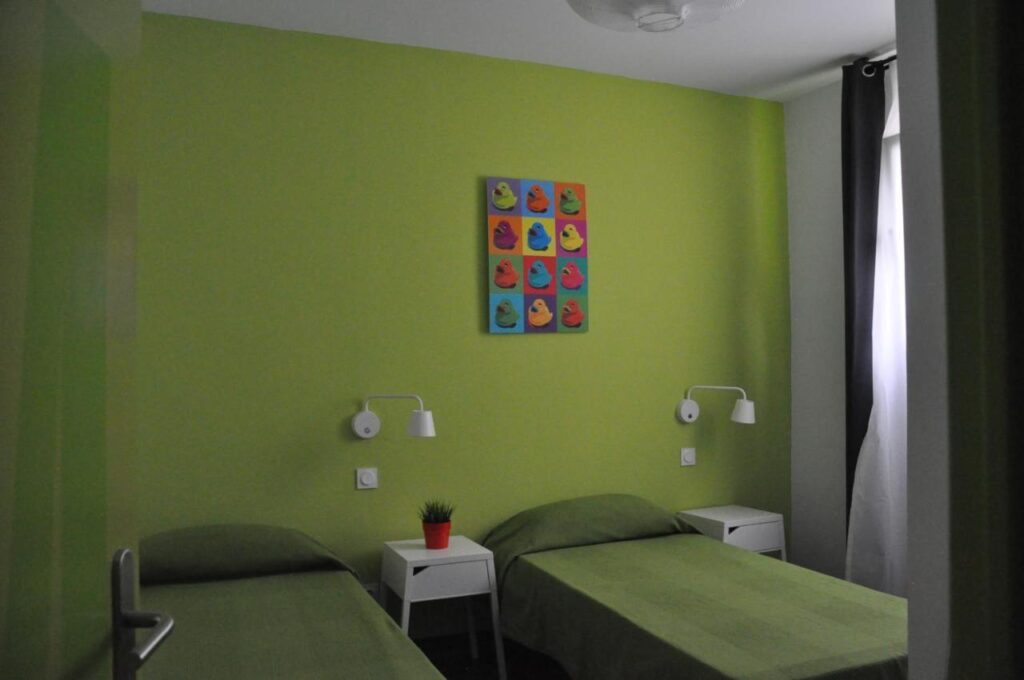 two single beds in a one bedroom with earth green painted walls
