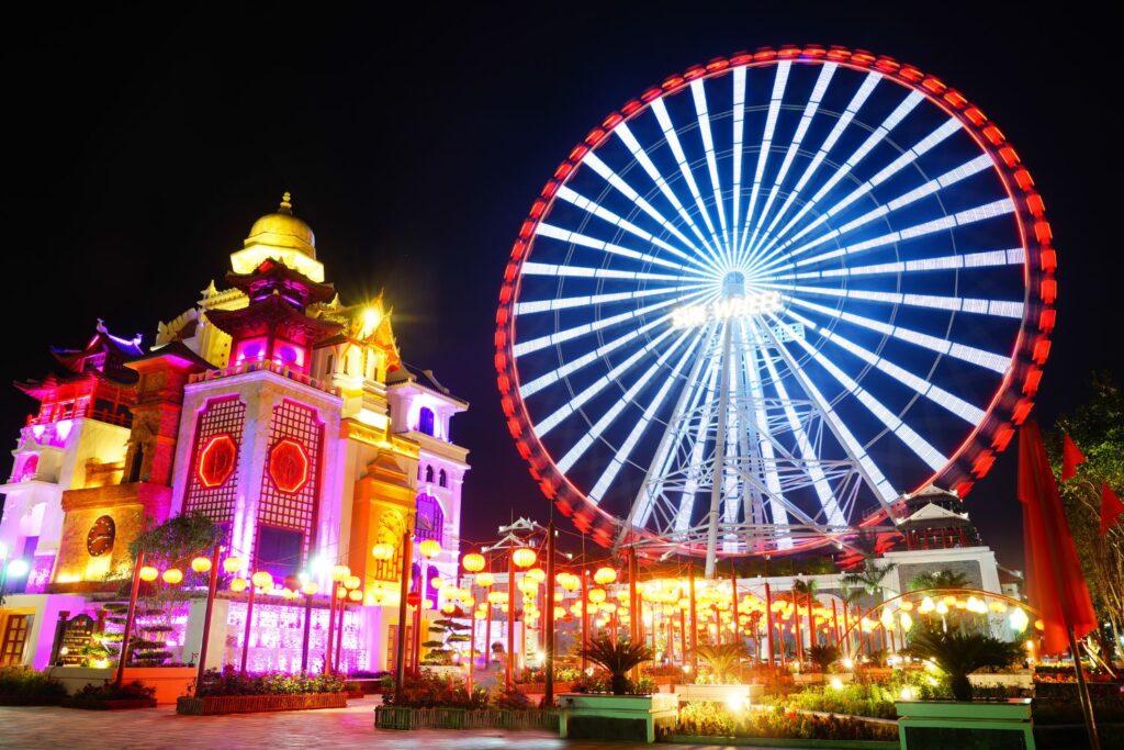 Ferris wheel at night with lighted temple, Da Nang