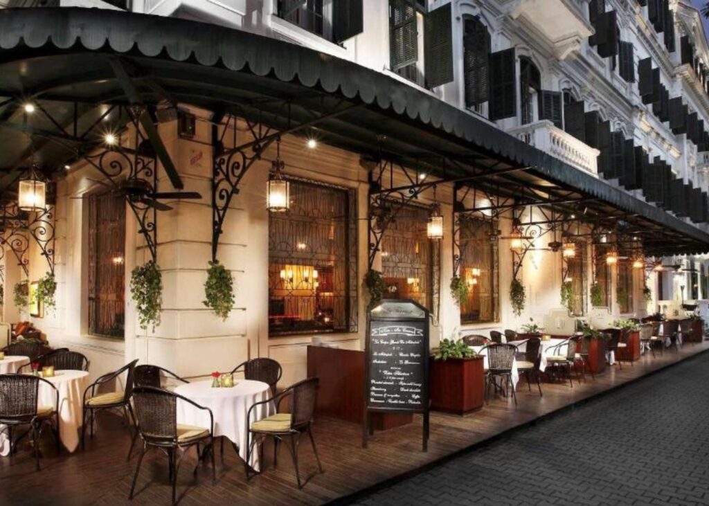 French facade at Sofitel Legend Metropole Hanoi with sidewalk seating
