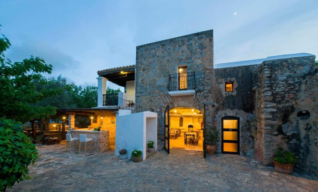 exterior view of the hotel made of stones and warm lighting inside