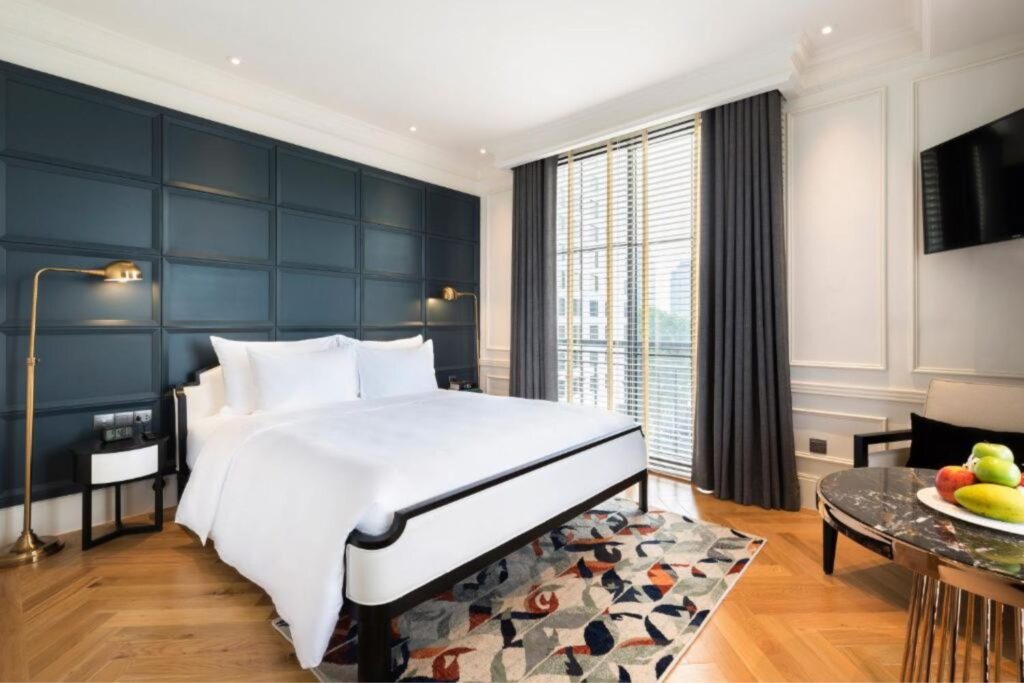 Interior of Bach Suites Saigon with dark accents aand white large bed