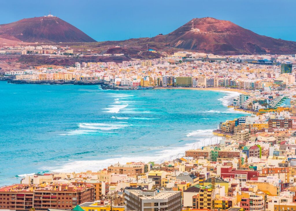 view of the colorful city, promenade, beach and mountains of