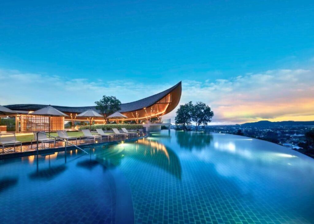 Main lodge and overhanging pool with city views at Noku Phuket
