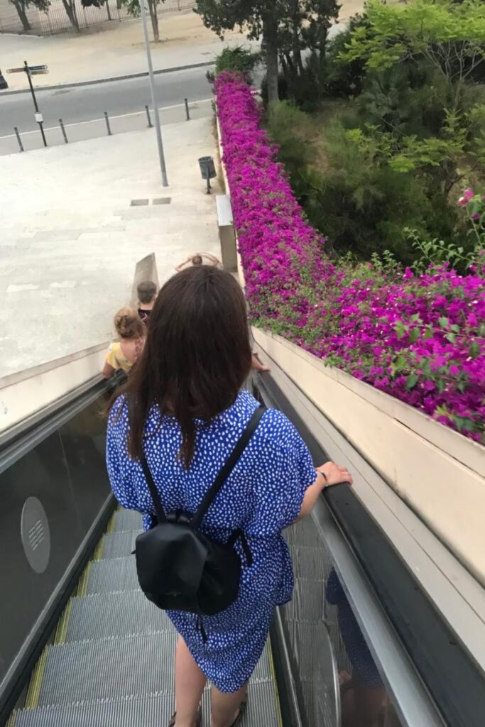 back of a woman standing on a Outdoor Escalator in Montjuïc