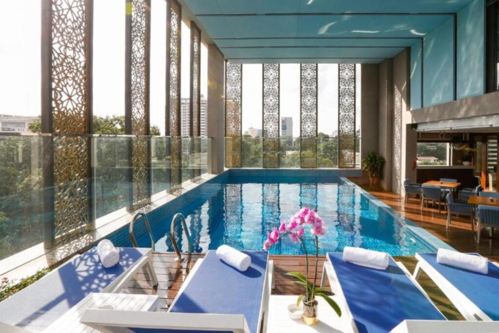 Pool area with traditional Vietnamese design and city view in Orchid Saigon Hotel