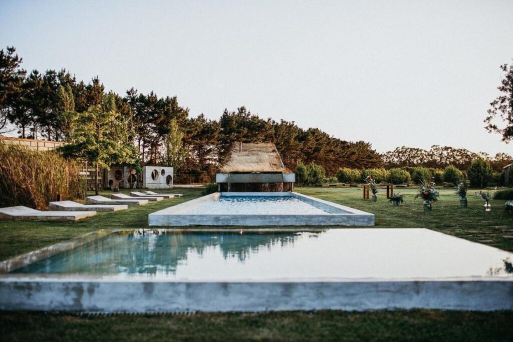 2 outdoor pools in a tranquil setting surrounded by plants and trees