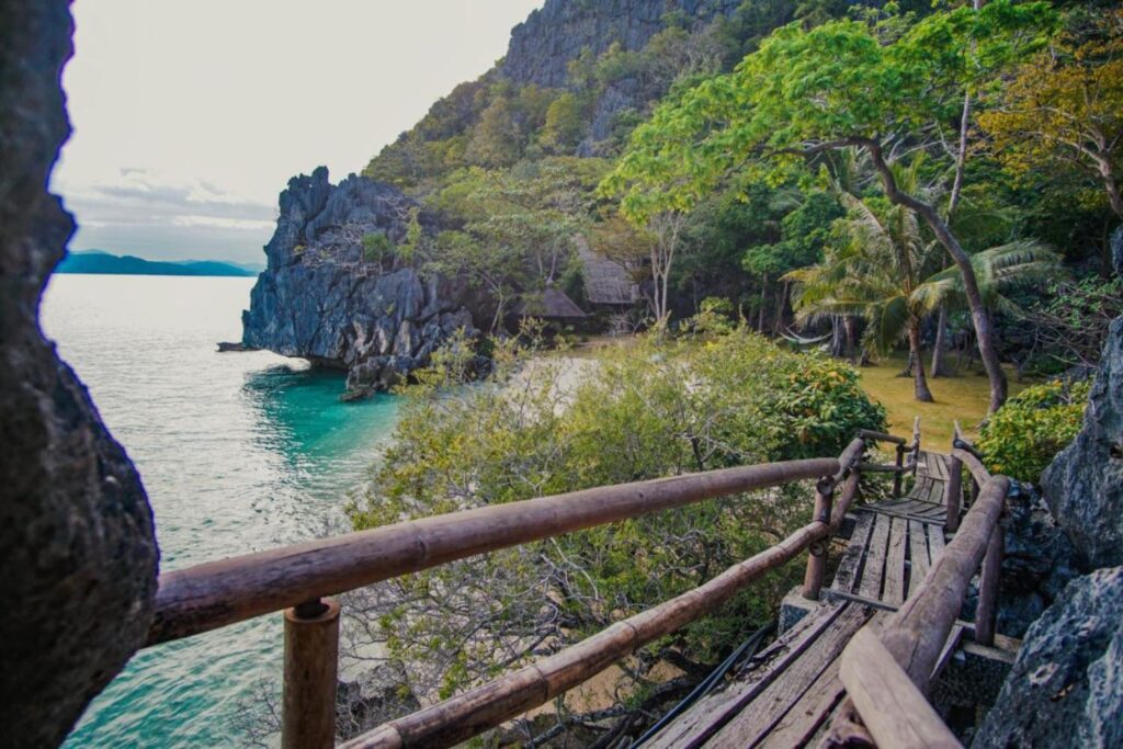 wooden pathway leading to the beach with beautiful rock formation