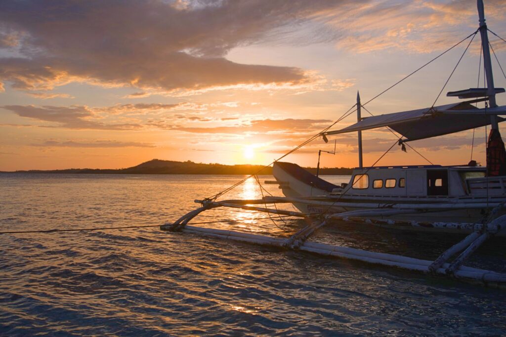 Sunset and a Filipino banca boat on the ocean in Balabac