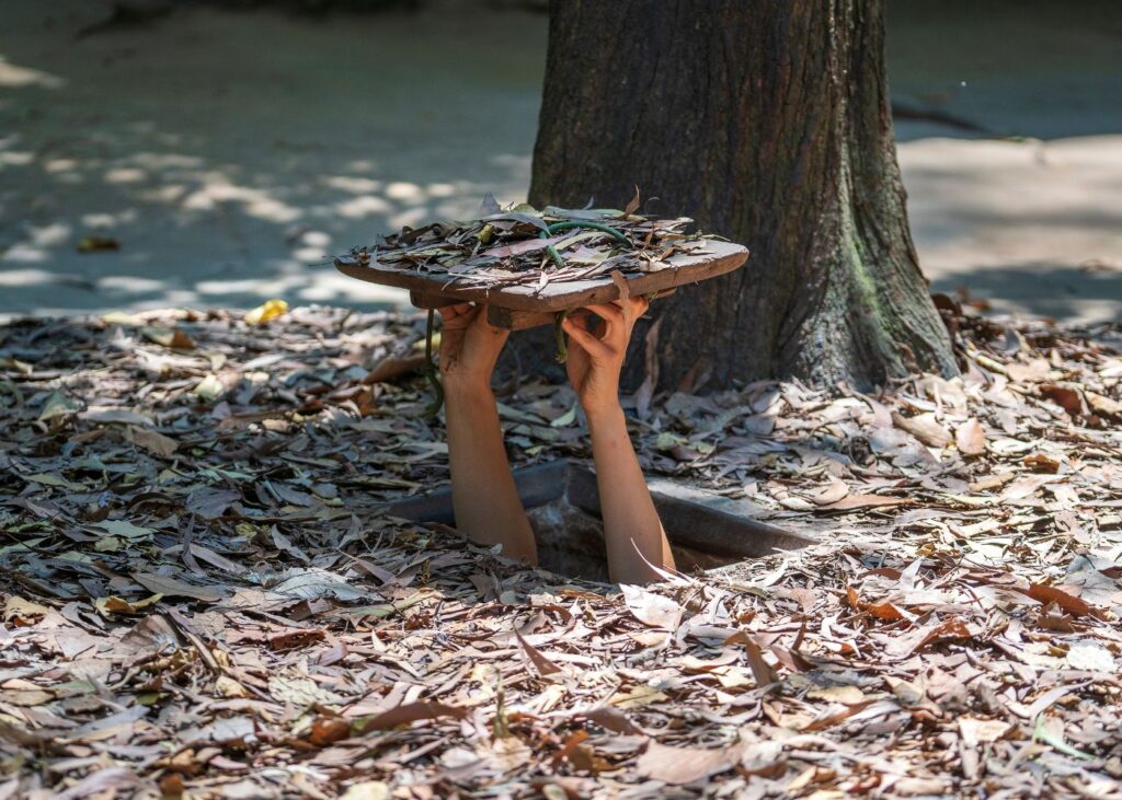 Tourist holding secret entrance to Cu Chi Tunnels in Ho Chi Minh