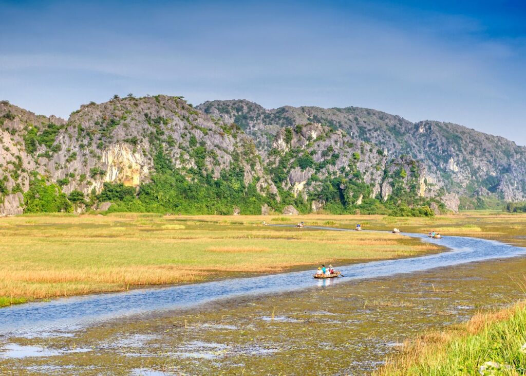 Travelers on a boat ride in Van Long Nature Reserve