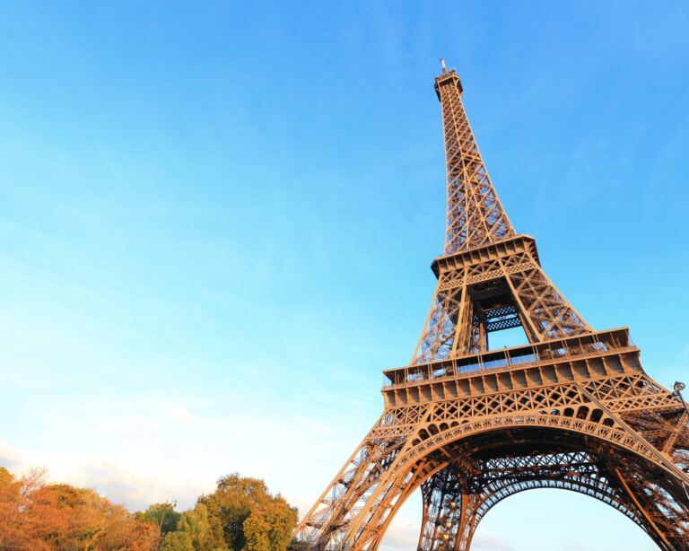 A photo of eiffel tower in Paris with blue sky.