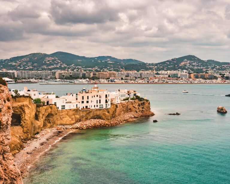 Aerial view of the bay, beach, old houses, of the upper area of Dalt Vila, in Ibiza, Spain.