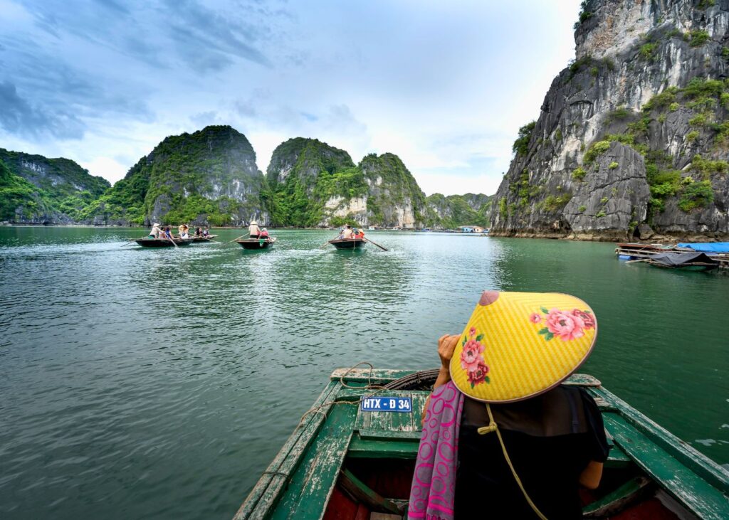 rear view of a woman in traditional Vietnamese hat on a boat in Halong Bay