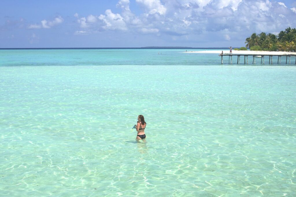 Woman wading in the crystal clear water of Onok Island