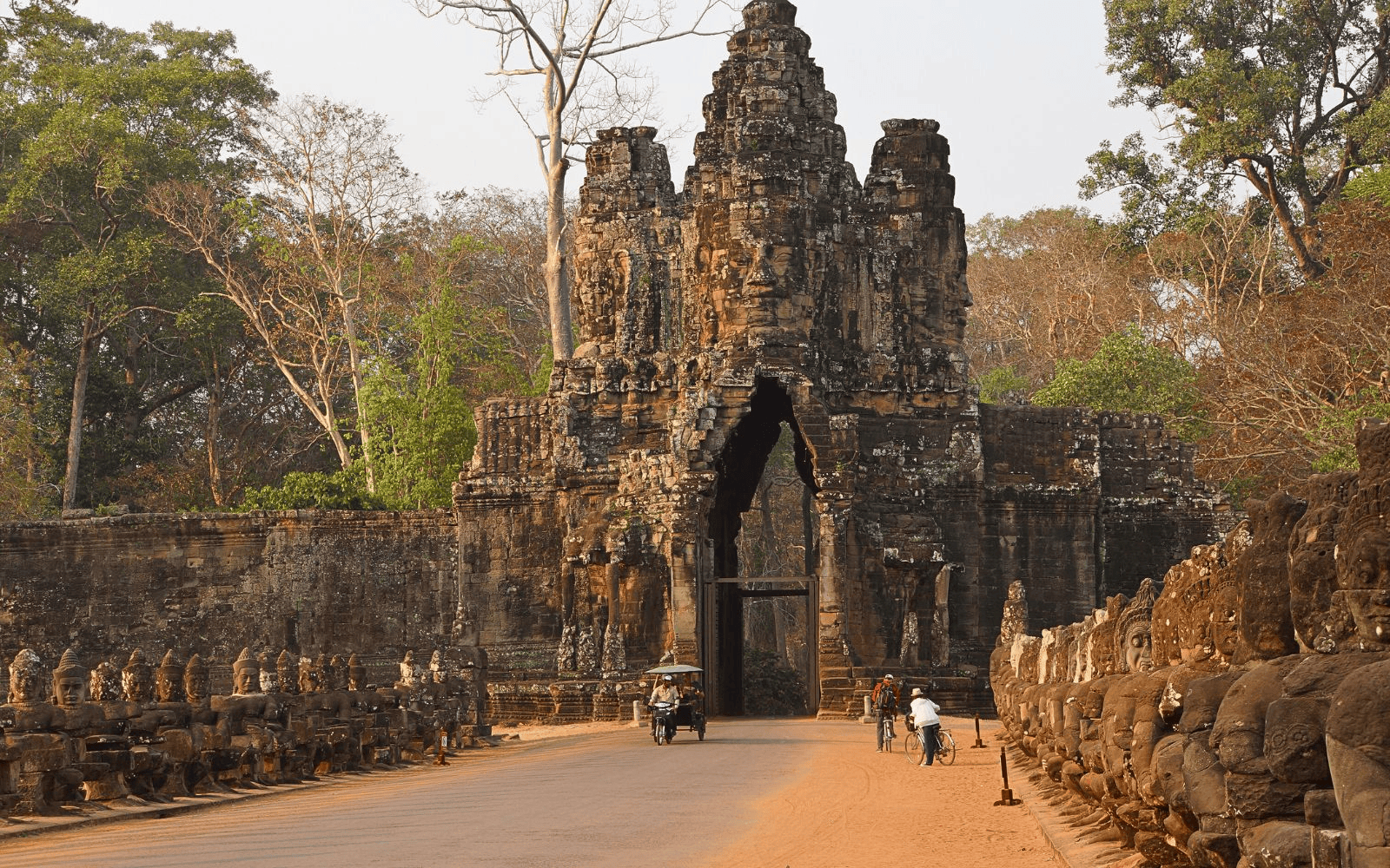 Tuk Tuk and pedestrians in front of one of the gates of Angkor Thom