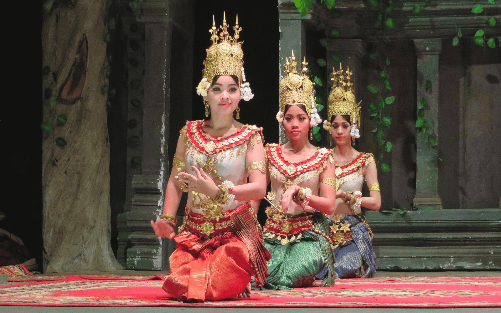 Three women hold performing Cambodian traditional Apsara dance