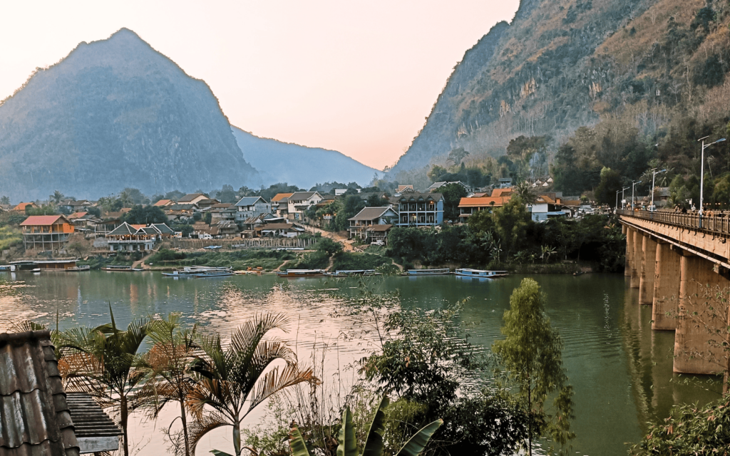 The adorable village of Nong Khiaw at sunset with limestone mountains in the background of the Nam Ou River, an off the beaten path destination in Laos-Abby