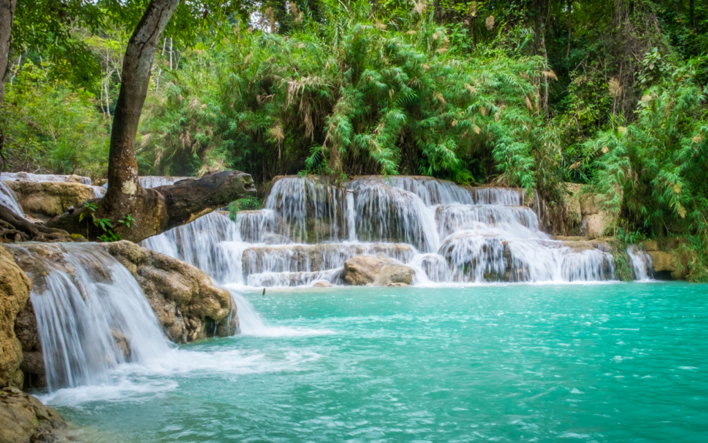 The emerald waters of Kuang Si Falls surrounded by lush greenery, one of the top attractions on any Lao itinerary