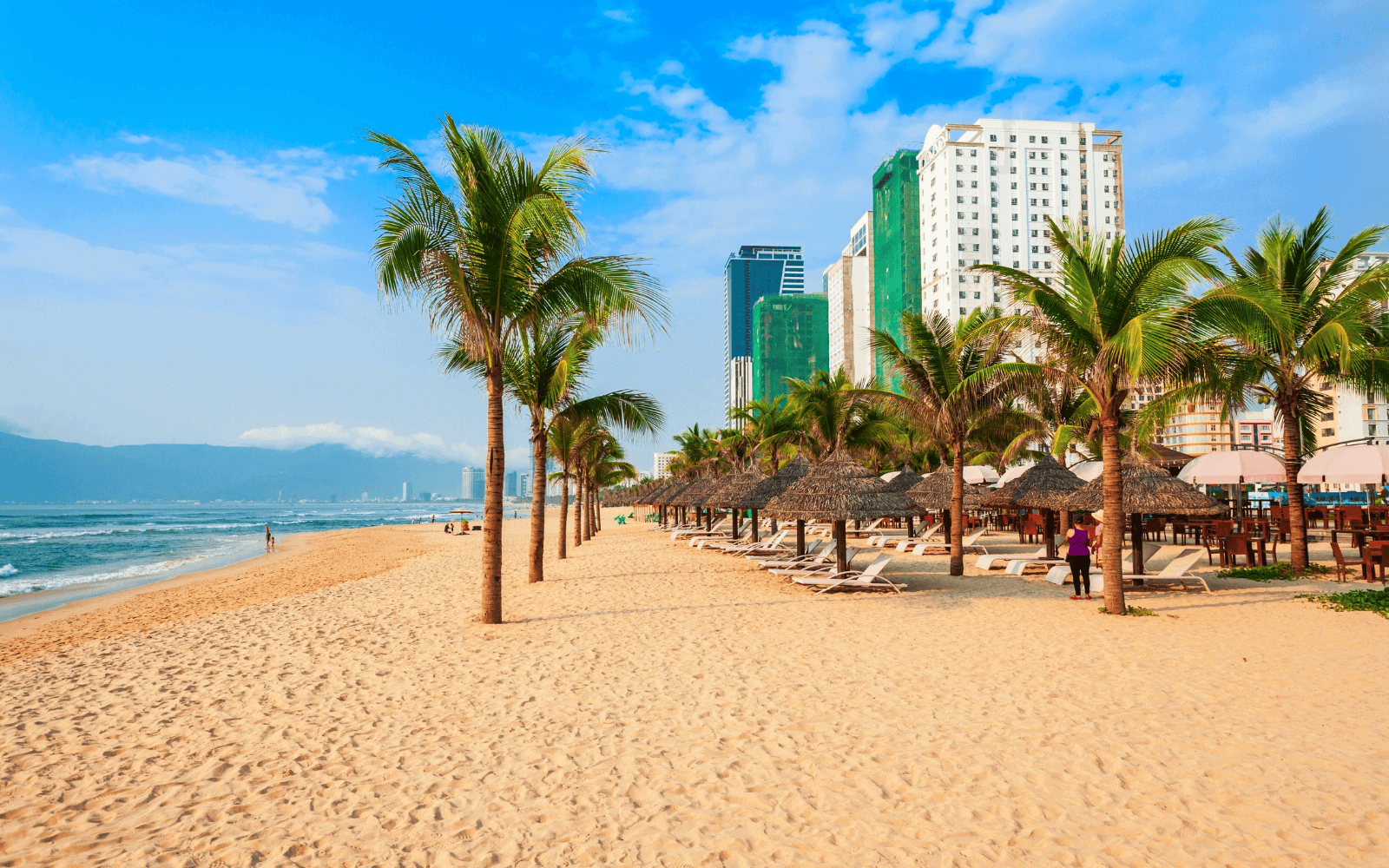 Golden sands of My Khe Beach or China Beach, Da Nang's most beautiful beach with palm trees and hotels in the background