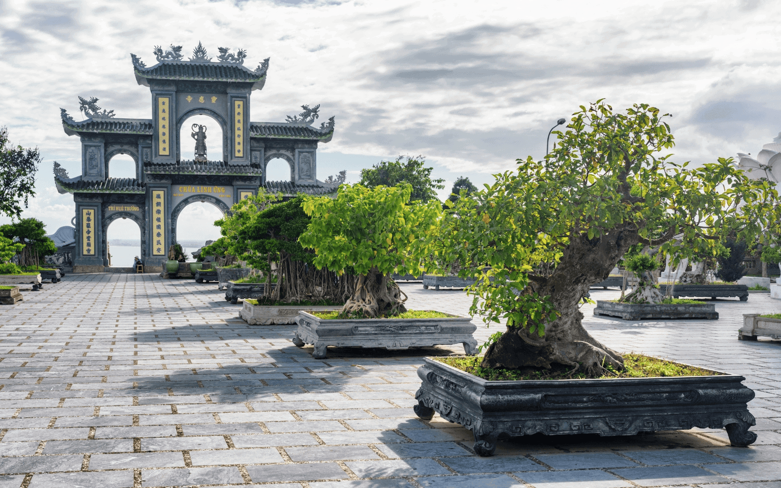 Linh Ung Pagoda in Da Nang Vietnam with trees in foreground and clouds