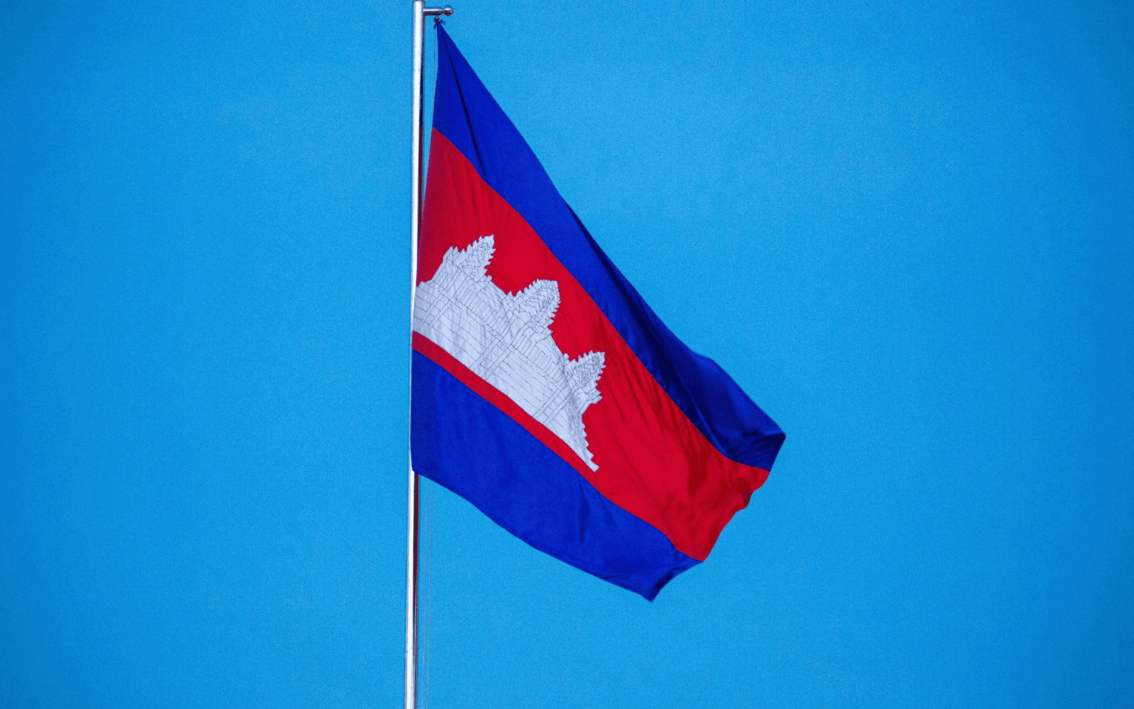 Red and blue Cambodian flag against a bright blue sky