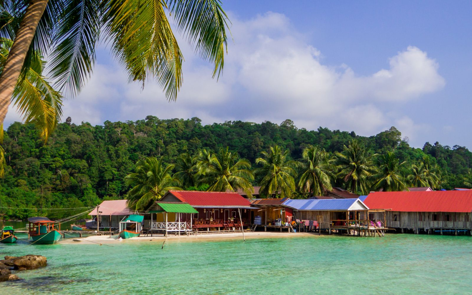 Beachfront building and jungle lined beach with turquoise water in the Cambodian islands